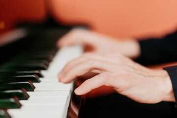Obraz premium Pianist hands playing jazz melody on black grand piano keys during a musician performance for concert promotion in an elegant studio with copy space background