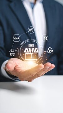 Businessman holding a glowing store icon with various e-commerce symbols, representing online business, digital marketing, and retail technology.