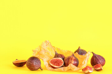 Obraz premium Paper with fresh juicy cut figs on yellow background