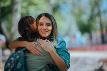 Fototapeta premium Happy Woman Hugging Her Best Friend on the Street. Acquaintances greeting each other on the street with enthusiasm and a hug