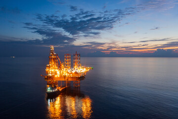 Obraz premium Aerial view of offshore jack up rig in a shipyard during sunset for oil and gas exploration and production.