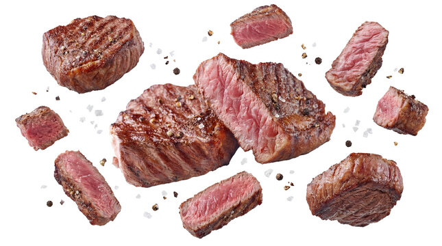 close-up overhead view of a selection of perfectly grilled steak cuts, seasoned with coarse salt and cracked black pepper, isolated on a transparent background.