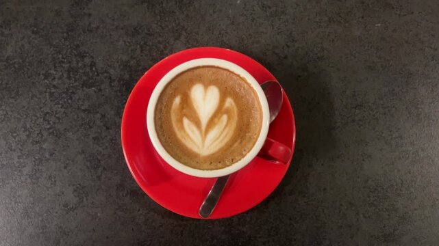 top view of hot cafe latte in the re d cup or mug. art. coffee shop, cafe, restaurant. dine, dining. white. isolated on iron black table background. light, lights. lamp, lamps. night. dark. high angle