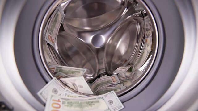 United States Dollars inside washing machine spinning in slow motion for money laundering and fraud concept.