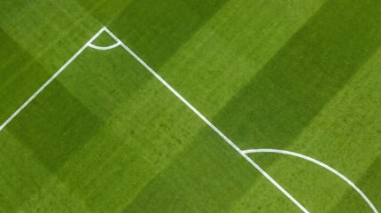 Obraz premium Aerial view of a vibrant green football field showing the corner arc and side line markings