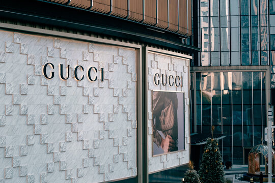 Guangzhou, China - January 18, 2026: Luxury Gucci storefront with illuminated logo sign and large fashion poster on marble facade. Elegant high-end boutique exterior in modern shopping mall