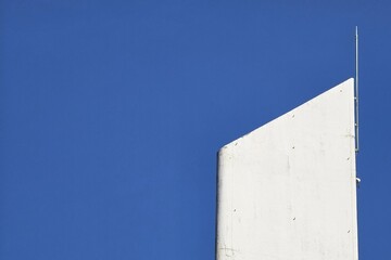Minimal View of the Top Section of Building Against a Clear Blue Sky.