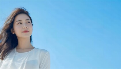 青空の下で希望に満ちた表情を見せる日本人女性