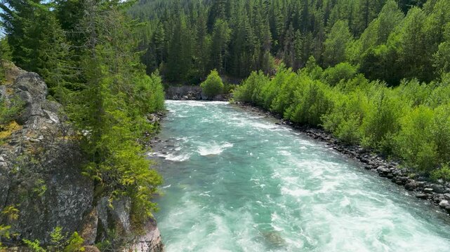 Aerial footage of a turquoise river winding through dense evergreen forest near Squamish, BC, showing clear water and lush conifer trees.