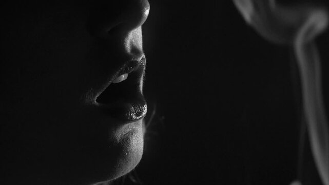 Extreme/Macro close-up of a woman taking a drag from a cigarette and exhaling smoke (Black & White).