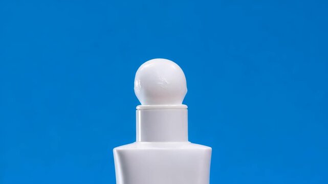 Closeup of minimalist skincare product tube with white foam on blue background highlighting clean beauty and cosmetic packaging in studio quality