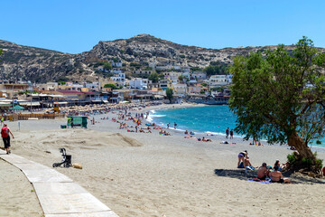Fototapeta premium Sunny Beach of Matala Bay with Tourists – Summer Holiday on Crete, Greece