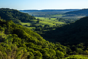 Obraz premium Stunning cliff formation in a lush green valley in Sao Paulo state. A landmark representing the region unique geology, farm pastures and the beauty of the Atlantic Forest biome