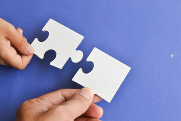 Connecting puzzle pieces in hands, hand with puzzle.