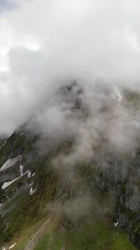 Fronalpstock Swiss Alps mountain landscape in a misty, cloudy environment aerial drone