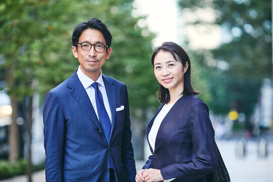 カメラ目線のビジネスマンとビジネスウーマン