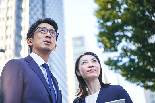 遠くを見るビジネスマンとビジネスウーマン