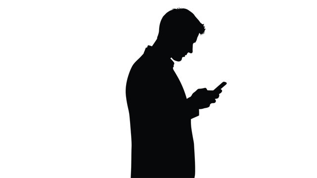 Silhouetted man looking down at a mobile phone in his hands