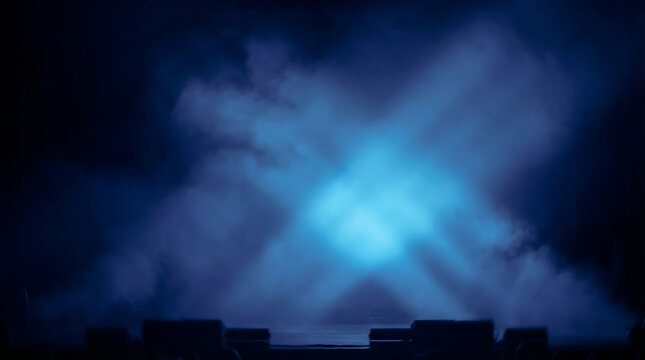 Intense blue stage lights create an X-shaped beam through thick smoke on a dark theater stage.
