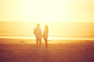 Fototapeta premium Back, couple and holding hands with sunrise at beach for love, romantic date and bonding on holiday. Space, people and adventure with affection, care and relationship commitment on vacation in nature