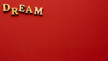 Wooden letters with which the word Dream has been written in English on a brown background.