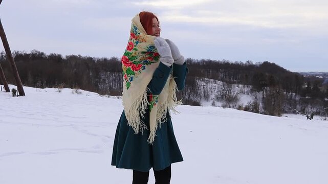 Joyful young woman during a winter walk in nature. Snow, activity, sincere emotions and seasonal mood.