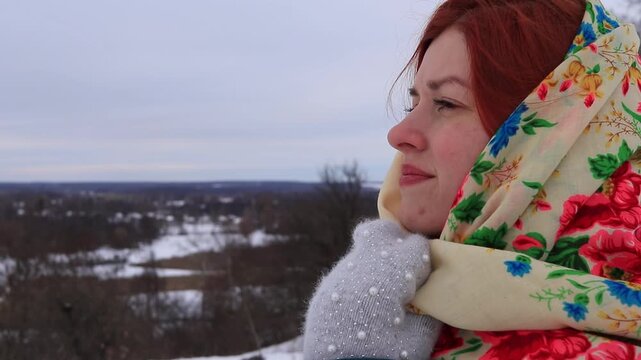 Beautiful girl with red hair in a traditional scarf winter portrait
