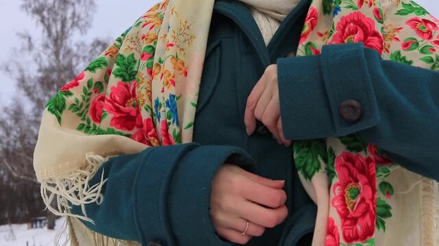 Close-up of female hands buttoning a warm winter coat