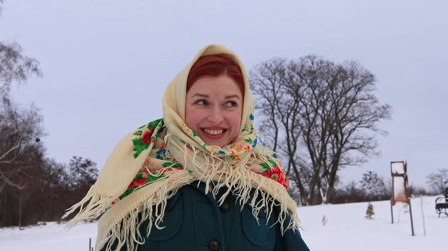 Beautiful girl with red hair in a traditional scarf winter portrait