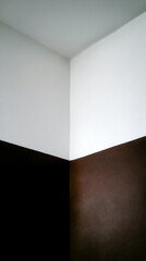 Fototapeta premium Unfinished corner of a room showing a sharp contrast between white and brown wall paint