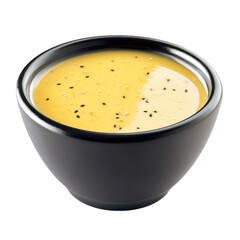 Creamy yellow sauce with black and white sprinkles in a black ceramic bowl isolated on white background