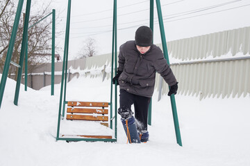 A European boy walks through deep snow.