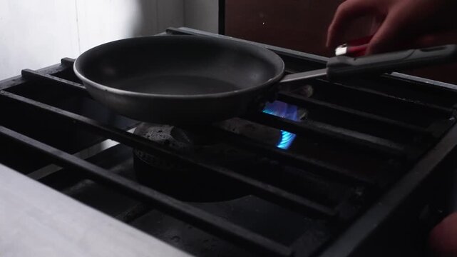 SLOW MOTION CLOSE UP SHOT OF A CHEF TURING ON A BURNER AT A KITCHEN