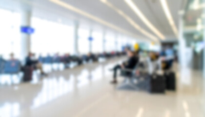 Fototapeta premium Abstract blurred background of airport departure terminal with waiting passengers.
