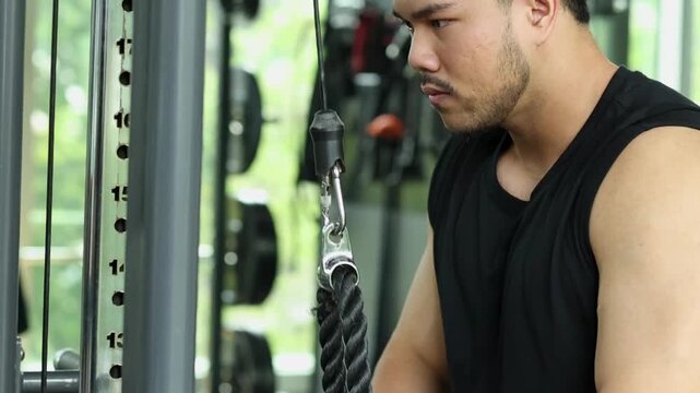 Close Up of Man Performing Tricep Rope Pushdowns in Gym