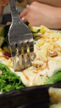Vertical Close-up of Fork Mixing Fresh Quinoa Salad with Dressing