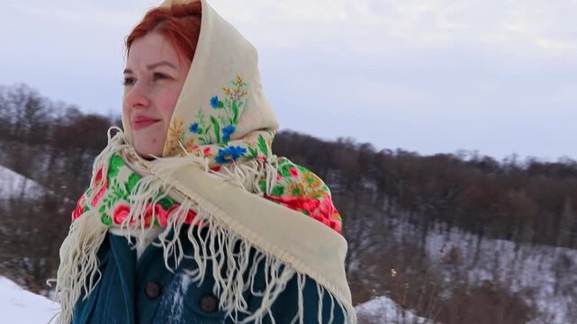Beautiful girl with red hair in a traditional scarf winter portrait