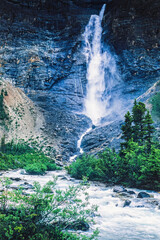 Riverbed by a mountain with a high waterfall