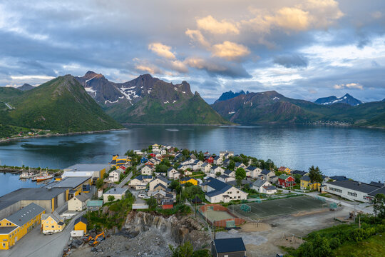 12 july 2025, Hus&oslash;y, Norway. Aerial, drone view of little villate Husoy and island in &Oslash;yfjorden fjord during sunset. Beautiful nature, mountains surrounding fjord, wonderful golden reflection from the