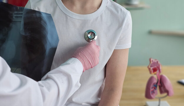 Doctor uses stethoscope on patient during a medical examination in a clinic