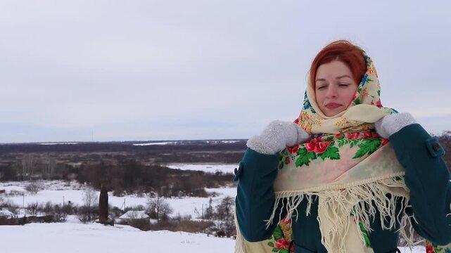 Beautiful girl with red hair in a traditional scarf winter portrait