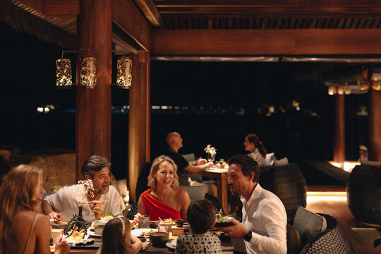 Happy family enjoying a fine dining experience at a coastal resort