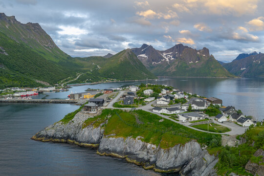 12 july 2025, Hus&oslash;y, Norway. Aerial, drone view of little villate Husoy and island in &Oslash;yfjorden fjord during sunset. Beautiful nature, mountains surrounding fjord, wonderful golden reflection from the