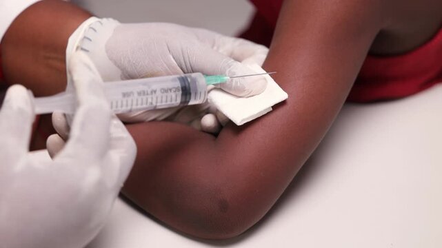 Closeup, African girl child receiving vaccination from pediatrician in medical office