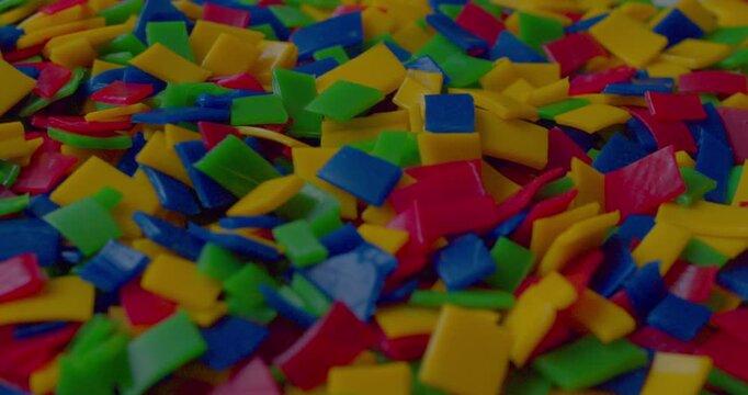 Footage of small vivid plastic pieces prepared for recycling purposes.
