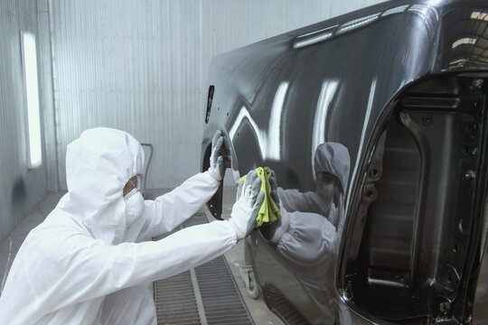 Painting the car in black color in the paint chamber on the serv
