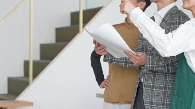 店舗施設で打ち合わせする店員・設計士・作業員