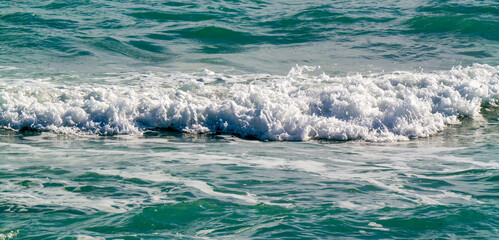 A small, freshly broken white wave at the sea. Taken on Derjba.