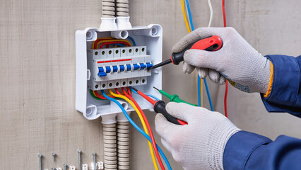 electrician repairing electrical outlet, Expert performs maintenance work, Specialist handles...