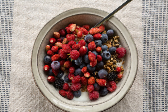 Healthy Mixed Berry and Granola Yogurt Breakfast Bowl with Spoon